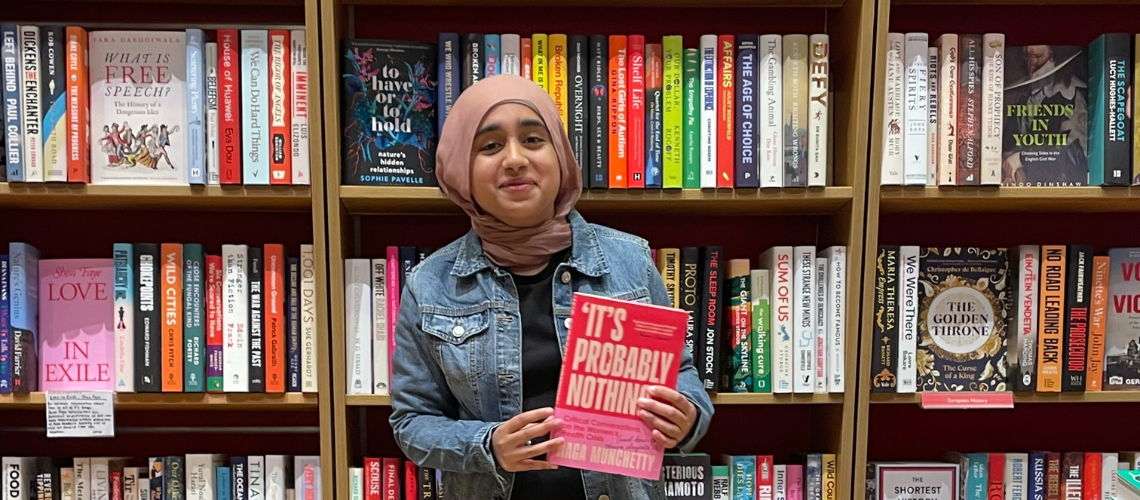 Zaynah holding a book with a title 'It's probably nothing'