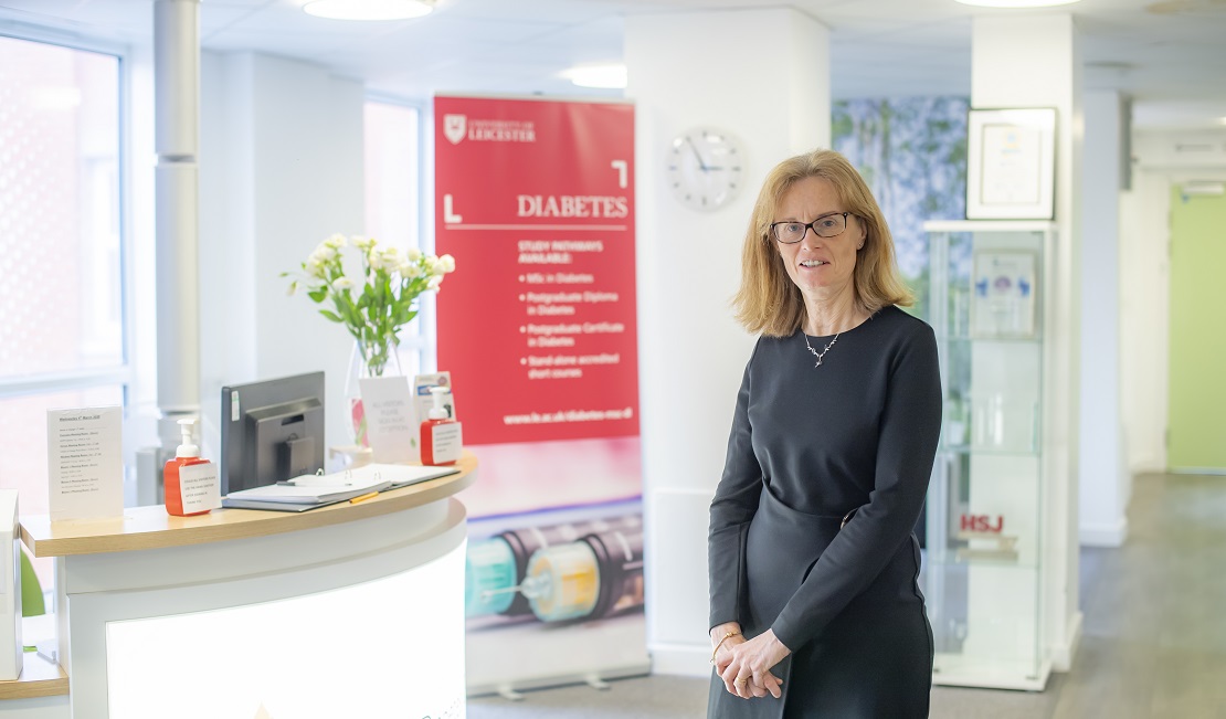 Melanie Davis standing in office reception area smiling at camera